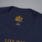 Close-up of a navy blue t-shirt collar showing a yellow printed graphic that reads 'FREEDOM'S BELL A CLOTHING' with a bell icon, on a neutral gray background.