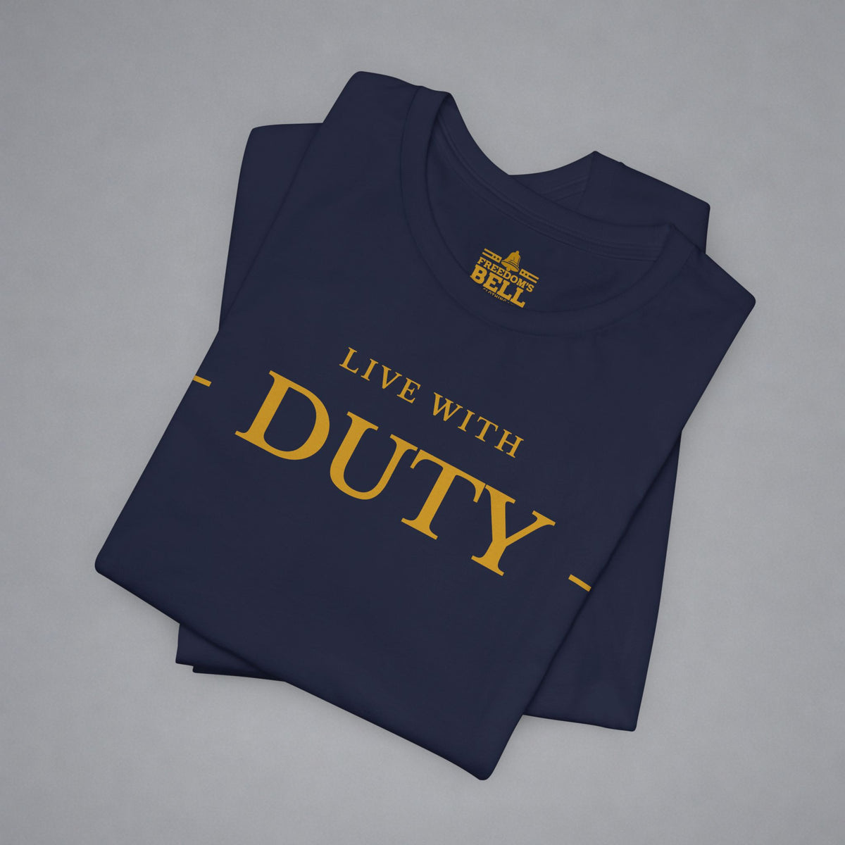 A folded navy blue t-shirt with gold text reading 'LIVE WITH DUTY' and a small 'BELL' logo printed inside the collar, displayed on a neutral gray background.