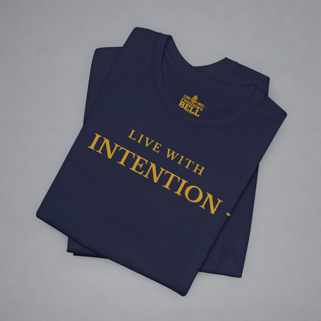 A folded navy blue t-shirt with gold text reading 'LIVE WITH INTENTION.