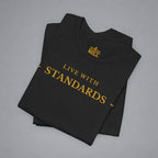 A folded black t-shirt with gold text reading 'LIVE WITH STANDARDS' and a gold 'Bell' logo printed inside the collar, displayed on a neutral gray background.