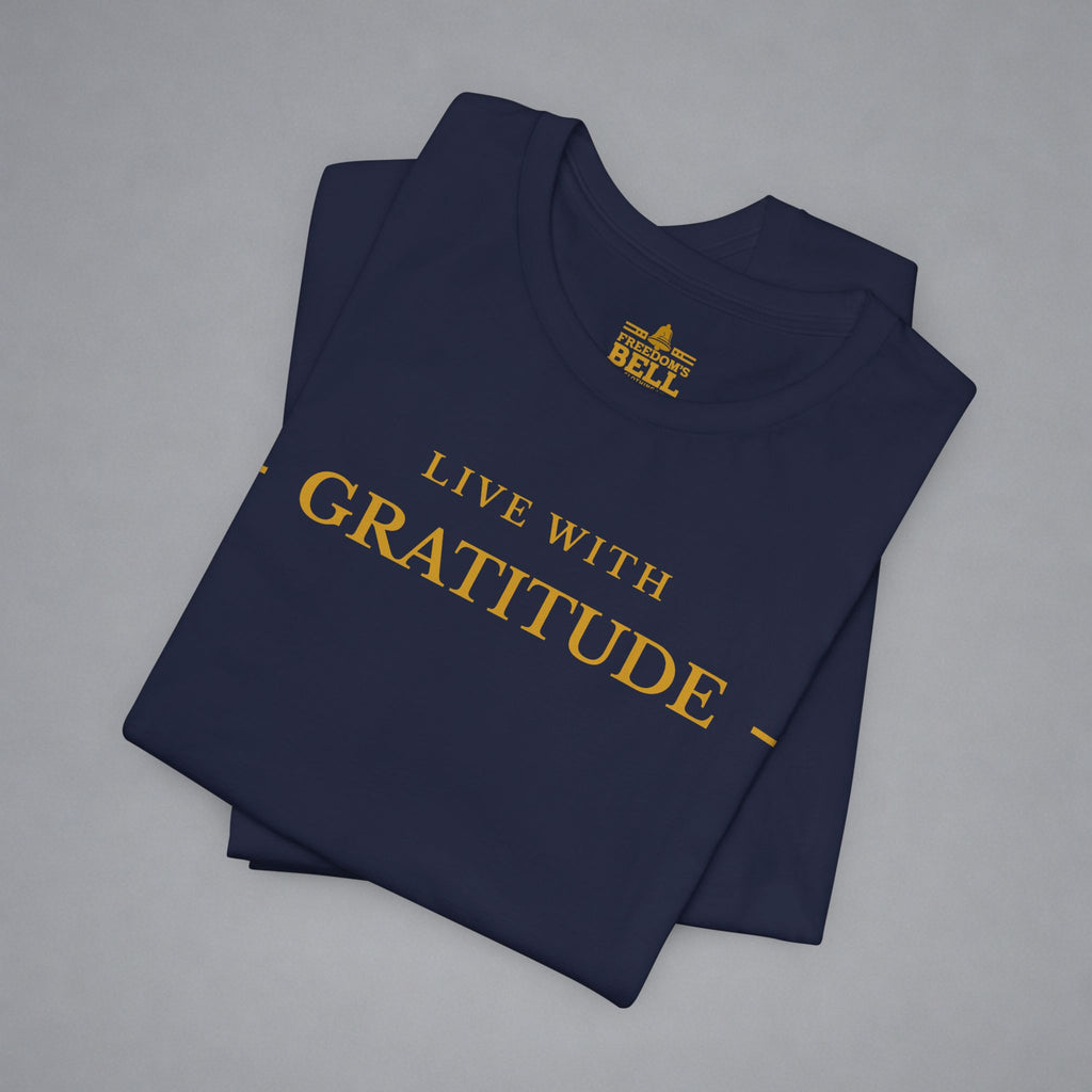 Folded navy blue t-shirt with 'Live with Courage' text on a gray background