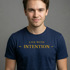 A man wearing a navy blue t-shirt with the text 'LIVE WITH - INTENTION -' printed in gold on the chest, set against a plain gray background.