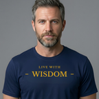 A man with short gray hair and a beard wearing a navy blue t-shirt with the text 'LIVE WITH - WISDOM -' printed in gold on the chest, set against a solid gray background.