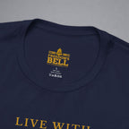 Close-up of a navy blue t-shirt showing the inner neck label with gold text reading 'FREEDOM'S BELL A CLOTHING' and part of the gold 'LIVE WITH' text on the chest, set against a neutral gray background.