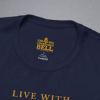 Close-up of a navy blue t-shirt showing the inner neck label with gold text reading 'FREEDOM'S BELL A CLOTHING' and part of the gold 'LIVE WITH' text on the chest, set against a neutral gray background.
