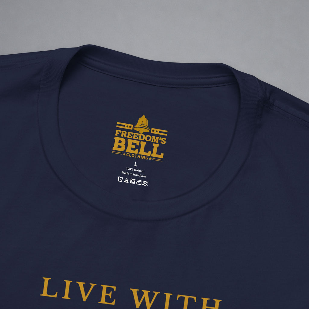 Close-up of a navy blue t-shirt showing the inner neck label with gold text reading 'FREEDOM'S BELL A CLOTHING' and part of the gold 'LIVE WITH' text printed on the front, set against a neutral gray background.