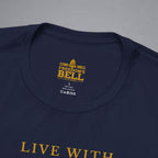 Close-up of a navy blue t-shirt showing the inner neck label with gold text reading 'FREEDOM'S BELL A CLOTHING' and part of the gold 'LIVE WITH' text printed on the front, set against a neutral gray background.